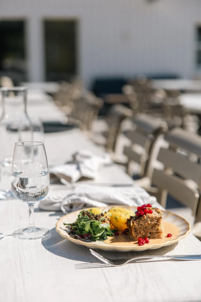 Ein elegantes Mittagessen mit Salat und Aufschnitt, serviert auf der Restaurantterrasse des Hotels mit Blick auf das ruhige Wasser des Vättern