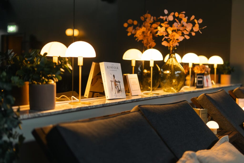 Stämningsfull lounge med glödande Panthella-lampor, Kinfolk-böcker och bladguldvaser för nyårsavkoppling på Starby S...
